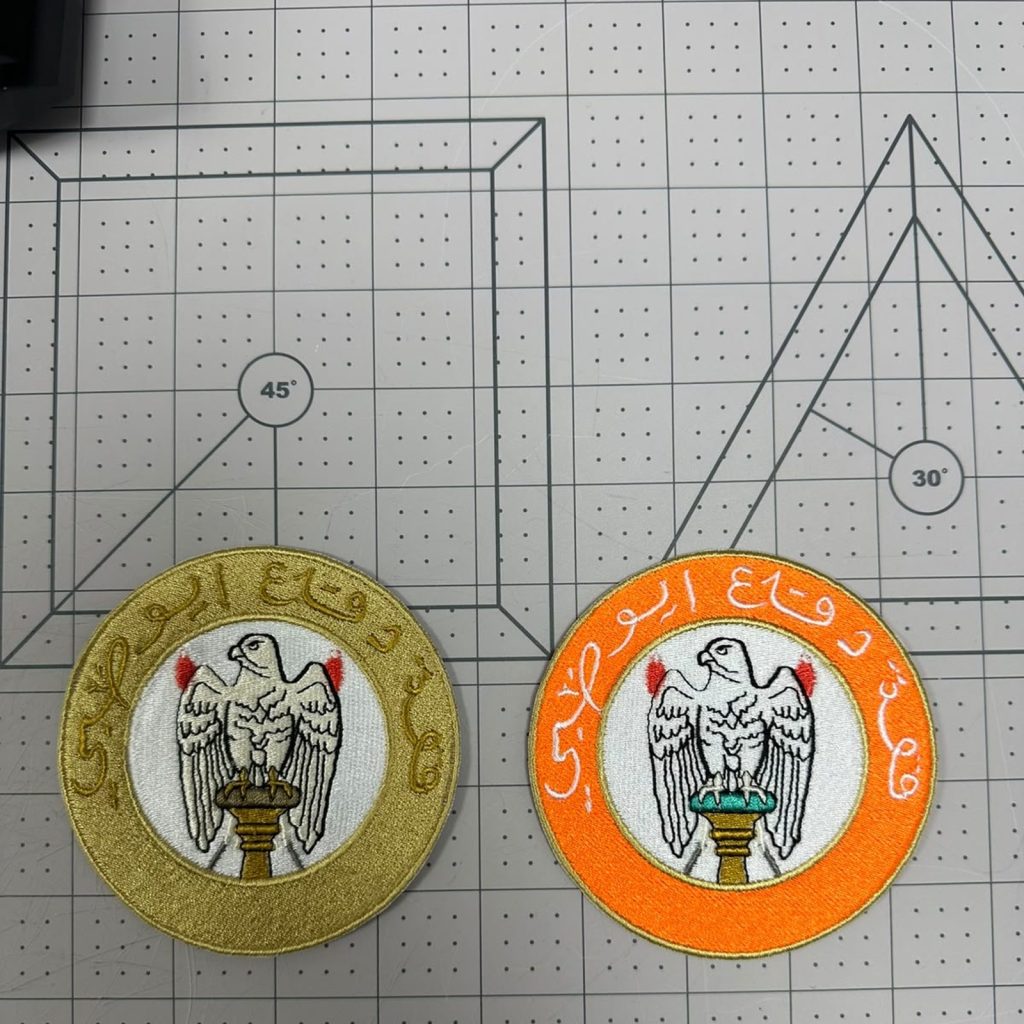 Custom embroidered UAE emblem patches in gold and orange