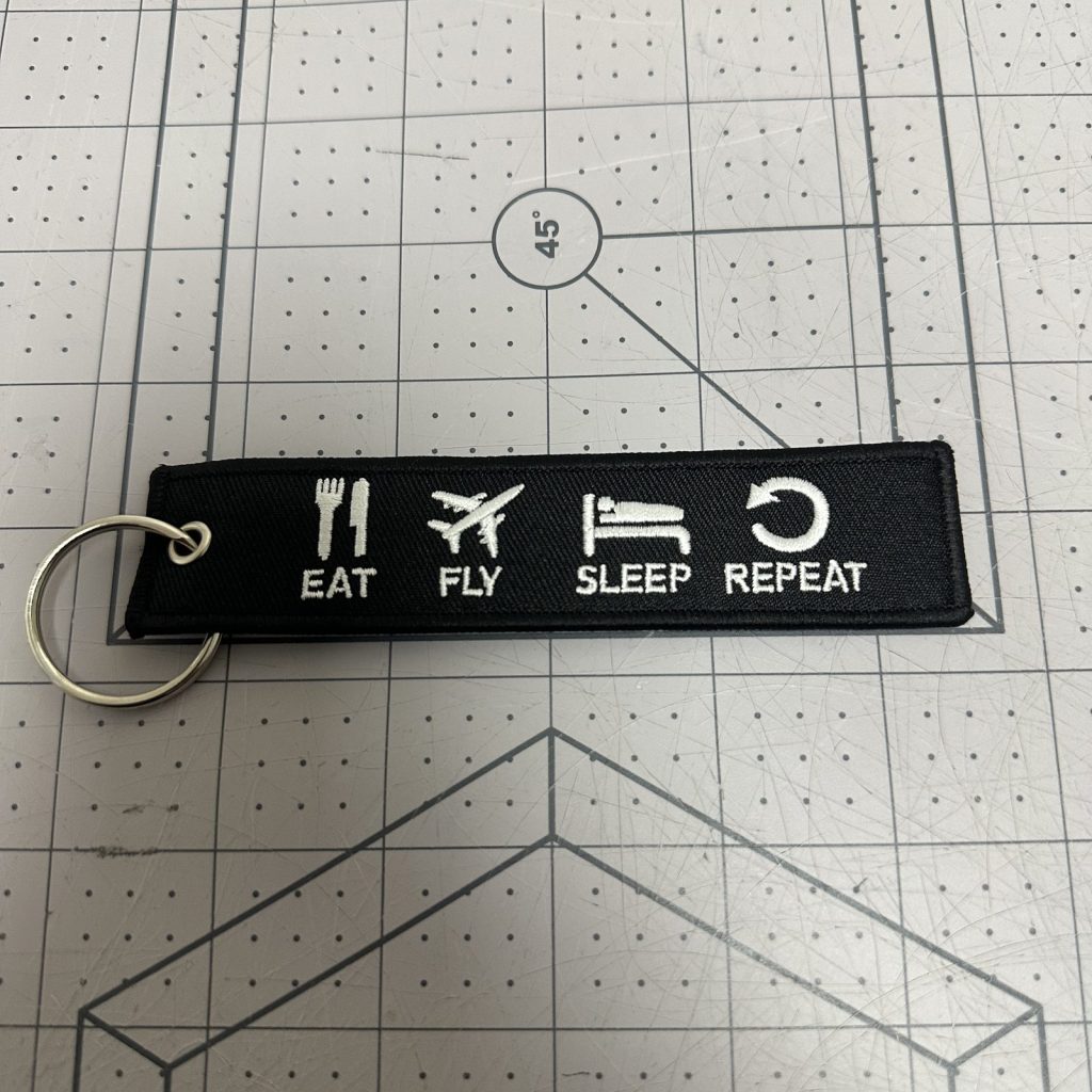 Custom embroidered keychain tag with icon artwork